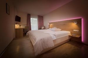 a bedroom with a large white bed with a purple light at Erkheimer Landhaus in Erkheim