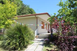 a small house with a bunch of flowers in front of it at Home Meditamondo in Fano