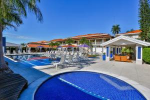 a swimming pool with chairs and a resort at Sun Valley Marília by Atlantica in Marília