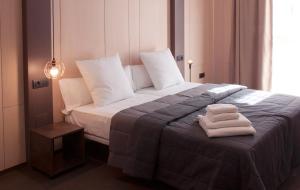 マラガにあるApartamentos NONO by Charming Stayのベッドルーム1室(ベッド1台、タオル2枚付)