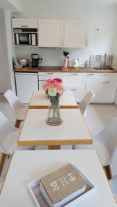 a vase of flowers on a table in a kitchen at Le Castel Guesthouse in Bayeux