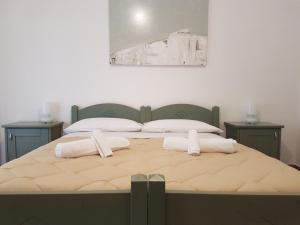 Una cama grande con dos toallas blancas. en Casa Santiago, en Agrigento