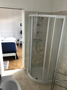 a bathroom with a shower with a sink and a bed at CYTRUS rooms in Marina di Massa