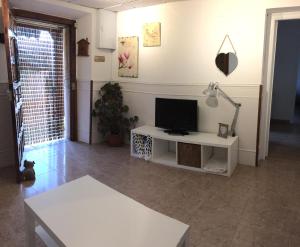 ein Wohnzimmer mit einem TV auf einem weißen Tisch in der Unterkunft Los Pinos de Cardes in Cardes
