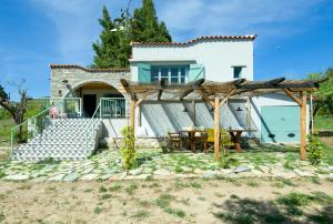 a small white house with a table and a patio at Avaton Farm in Ouranoupoli