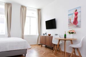 Schlafzimmer mit einem Bett, einem Tisch und einem TV in der Unterkunft Bear Fountain Residence in Prag