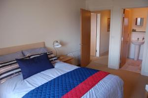 a bedroom with a bed with a blue and red blanket at Apartment 2 The Waterfront in Portaferry