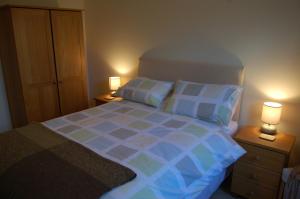 a bedroom with a bed with two lamps on night stands at Apartment 2 The Waterfront in Portaferry