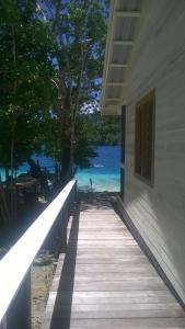 a boardwalk leading to a house with a view of the ocean at Evis Resort at Nggatirana Island in Halisi