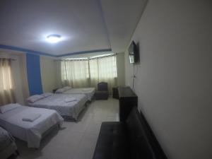 ein Hotelzimmer mit 2 Betten und einem TV in der Unterkunft Discovery in Panama-Stadt