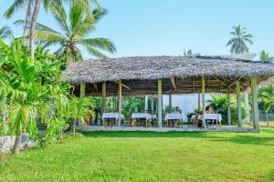 a gazebo with tables and chairs and palm trees at Hotel Ancient Village in Polonnaruwa