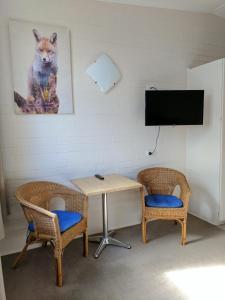 a room with a table and two chairs and a tv at Lake Bolac Motel in Lake Bolac