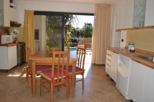 a kitchen with a wooden table and chairs and a table at Casa Cora in Villa Carlos Paz