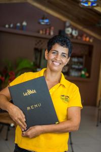 a man in a yellow shirt holding a book at La Quinta Sarapiqui Lodge in Sarapiquí +66 photos
