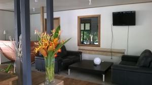 een woonkamer met een vaas met bloemen op een tafel bij Evis Resort at Nggatirana Island in Halisi