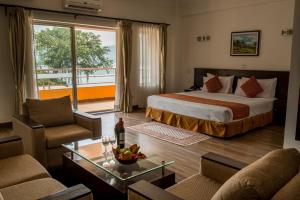 um quarto de hotel com uma cama e uma sala de estar em Waterfront Resort by KGH Group em Pokhara