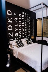 a bedroom with a bed with a black and white headboard at M Boutique Kampar in Kampar