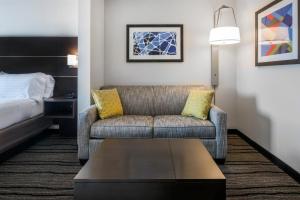 Holiday Inn Express Hotel & Suites Livermore, an IHG Hotel في ليفرمور: غرفة معيشة مع أريكة وسرير
