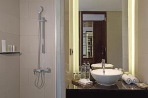 y baño con lavabo y ducha. en Golden Tulip Jineng Resort Bali, en Kuta