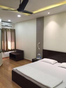 1 dormitorio con 1 cama y ventilador de techo en Pamposh Guest House GK II Market, en Nueva Delhi