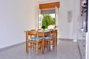 トッレ・サン・ジョヴァンニ・ウジェントにあるVilla Esperanzaの窓付きのキッチン(テーブル、椅子付)