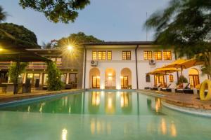 
a large swimming pool in front of a large building at The Elephant Stables in Kandy
