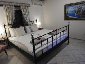 1 dormitorio con 1 cama grande con almohadas blancas en Karst Stone Cottage, en Štanjel
