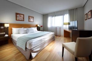 pokój hotelowy z dużym łóżkiem i biurkiem w obiekcie Exe Getafe w mieście Getafe +37 zdjęć