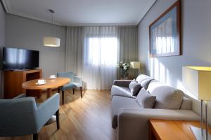 salon z kanapą i stołem w obiekcie Exe Getafe w mieście Getafe