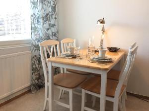 a dining room table with four chairs and a table and a lamp at City Apartments in Jyväskylä