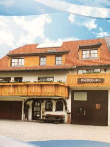 un gran edificio de madera con un cartel. en Gästehaus zur Mühle Dehm, en Friedrichshafen