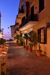 a street with tables and potted plants next to a building at Elia Palazzo Hotel in Chania