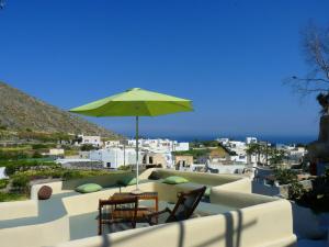 a patio with a table and an umbrella at Barbarossa Suites in Emporio Santorini