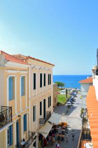 uitzicht op een straat met gebouwen en de oceaan bij Elia Palazzo Hotel in Chania