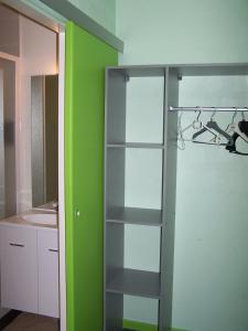 a glass shelf in a bathroom with a green wall at le lichou in Vallon-en-Sully