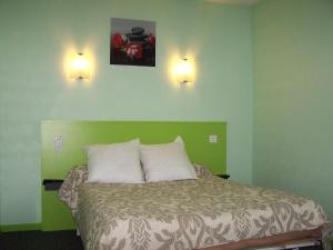 a bedroom with a bed with two lights on the wall at le lichou in Vallon-en-Sully