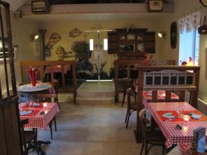 restauracja ze stołami i krzesłami w pokoju w obiekcie L'Ecurie w mieście La Pommeraye