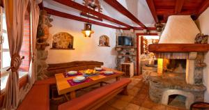 a living room with a table and a fireplace at The Ultimate Escape - traditional cottage & private pool in Selca