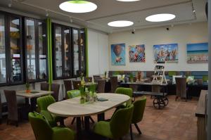 ハイムバッハにあるFerienapartments Cafe Stilbruchのダイニングルーム(テーブル、緑の椅子付)