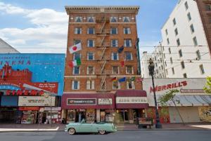 an old green car parked in front of a building at Aida Plaza Hotel in San Francisco