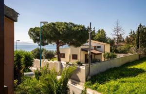 una casa con una valla y un árbol en Spacebility Beach - self check-in, en Quartu SantʼElena