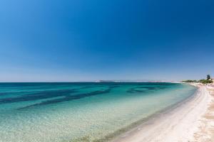 vistas a una playa con cielo azul y al océano en Spacebility Beach - self check-in, en Quartu SantʼElena