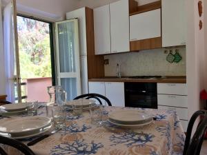 una cocina con una mesa con platos y vasos. en Le Sprizze Mare, en Marciana Marina