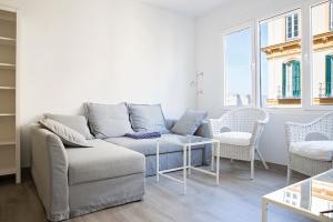 a living room with a couch and a table at Suncity Flat Victoria in M&aacute;laga