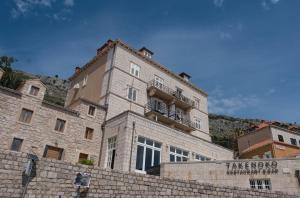 un grand bâtiment en pierre au-dessus d'un mur dans l'établissement Ragusina luxury apartments, à Dubrovnik