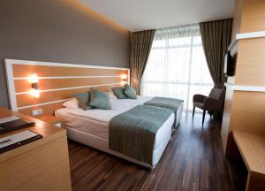 Un pat sau paturi într-o cameră la Fourway Hotel&Spa