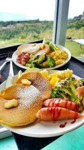 two plates of food with hot dogs and vegetables at White Sand Beach 32 in Green Island