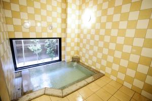 a bath tub in a room with a window at Hotel Route-Inn Fujieda-Eki Kita in Fujieda