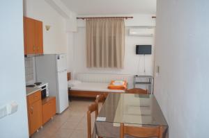 a small kitchen with a table and a refrigerator at Irini Apartments in Keramoti