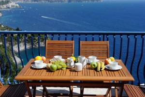 a wooden table with fruit on top of a balcony at L'ancora in Conca dei Marini